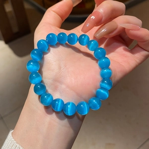 Macro shot of blue cat eye stone beads on the bracelet showing the glowing optical band