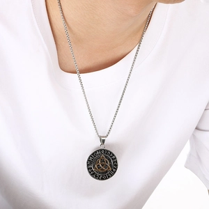 Detail shot of a Viking rune necklace featuring a golden Triquetra symbol on a steel pendant