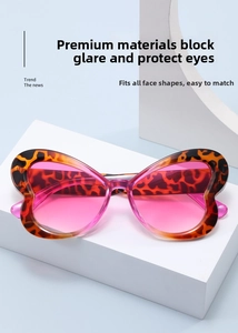 Detail of butterfly-shaped tortoiseshell sunglasses with pink gradient lenses on a stand