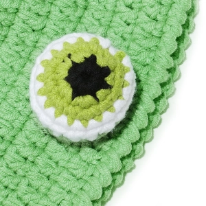 Detailed macro view of green knit octopus eyes hat with layered crochet textures