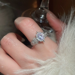 Close-up of elegant silver ring with purple heart-shaped zircon and plush cuff details
