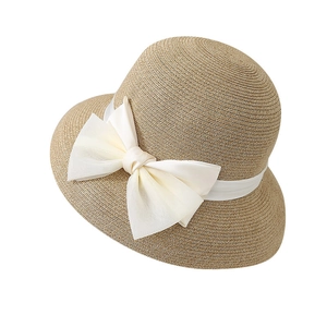 Women's straw sun hat with large cream bow for beach vacations and UV protection