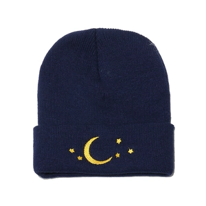 Gros plan détaillé de la broderie lune et étoile sur un bonnet bleu marine à revers