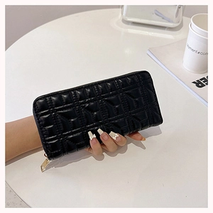 Close-up of black quilted leather long wallet with zipper and elegant embroidery pattern