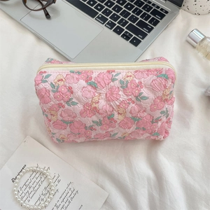 Close-up of quilted floral makeup bag with cute rabbit pattern and soft fabric texture