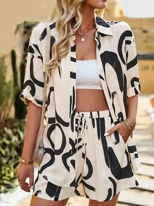 Detail of artistic black patterns on beige summer shirt and drawstring shorts