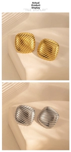 Macro detail of square geometric earrings with textured diagonal gold and silver stripes