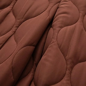 Détail macro du tissu matelassé marron avec motif en oignon pour veste d'hiver