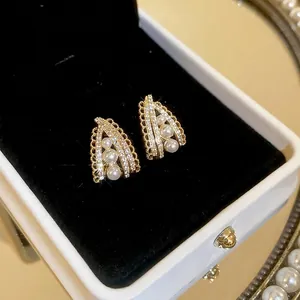 Lace-edged pearl earrings with zircon inlay on a golden base in a luxury jewelry box