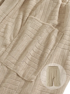 Detail of khaki waffle knit men's shorts showing textured fabric and drawstring waist