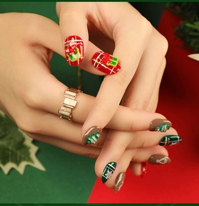 Detailed view of Christmas press-on nails featuring red plaid and festive tree patterns