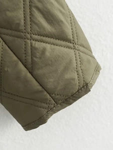 Detailaufnahme einer olivgrünen Steppjacke mit präzisem Rautensteppmuster und Doppelnähten