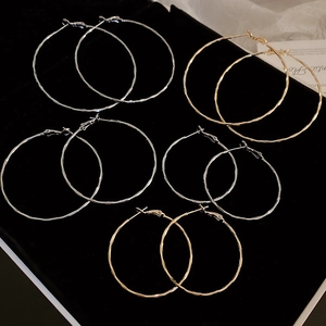 Detailed set of 5 pairs of metal hoop earrings in gold and silver on black velvet display