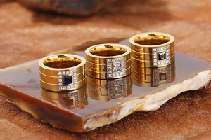 Three gold stainless steel rings with blue, white, and black square zircon inlays