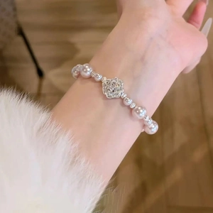Gros plan d'un bracelet de perles roses avec breloque fleur de zircon raffinée