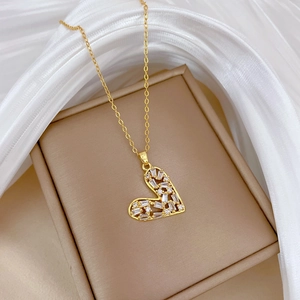 Close-up of golden hollow heart pendant with sparkling zircons on a jewelry box