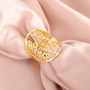Detail of gold hollow ring with celestial moon and star motifs on soft pink silk