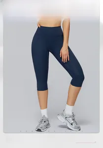Detail view of navy blue high-waisted yoga leggings on model for athletic fitness