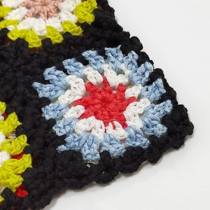 Macro shot of colorful granny square crochet patterns with detailed hand-stitched textures