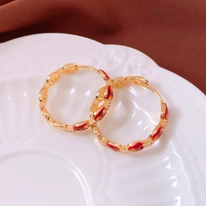 Detailed shot of 18k gold plated hoop earrings with red heart enamel and cubic zirconia