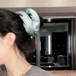 Large light blue satin pillow scrunchie shown on a model's hair bun with a soft texture