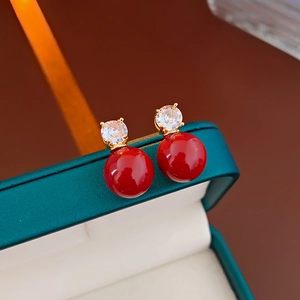 Macro d'oreilles en perles rouges avec zircons étincelants et détails plaqués or