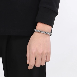 Détail du bracelet en acier titane argenté avec fermoir OT en forme de cœur sur le poignet