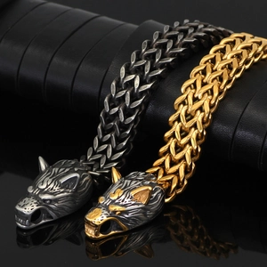 Close-up of wolf head bracelets in silver and gold finish with braided metal chain link