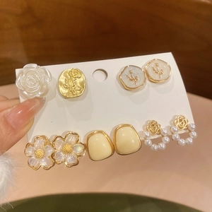 Dettaglio di un set da 6 paia di orecchini a fiore e perle in oro e bianco