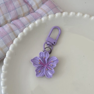 Detail eines lila Kirschblüten-Schlüsselanhängers auf einem Dekoteller