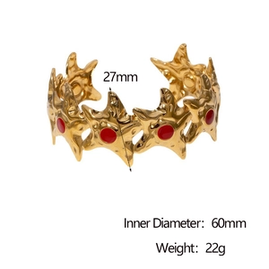 Detail showing 18k gold starfish cuff with hammered texture and red enamel center