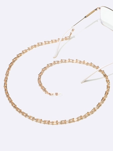 Macro shot of stylish gold industrial U-link eyewear chain with white rubber connectors