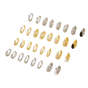 Luxurious gold and silver huggie earrings with zircon inlays and enamel detail on white background