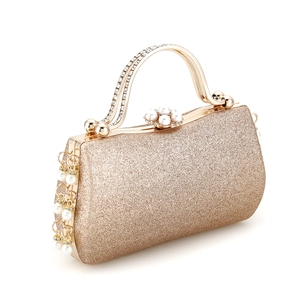 Detailed close-up of a gold sequin evening clutch with pearl and rhinestone handle accents