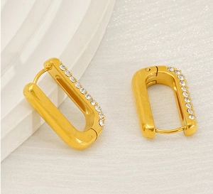 Macro detail of U-shaped gold plated earrings with sparkling zircon gemstones