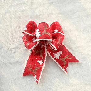 Red Christmas ribbon bow with gold reindeer and white snowflake patterns for gifts