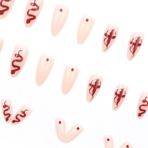 Almond shaped press-on nails with nude base, red snake, and cross patterns in a neat layout