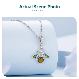 Macro shot of S925 sterling silver firefly pendant with green enamel wings and zircon