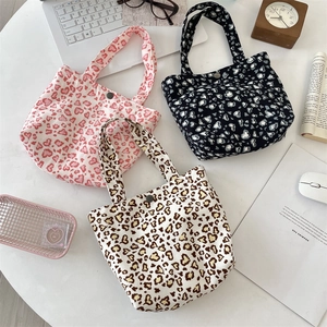 Detailansicht der Canvas-Taschen mit Herz-Leopard-Print und metallischem Druckknopf