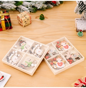 Close-up of wooden Christmas tree ornaments featuring Santa and angels in display boxes
