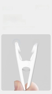Close-up of white plastic clothes peg with smooth non-slip wave design and metal spring