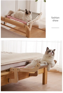 Detail of solid wood cat hammock hanging on bed frame with pink fabric support