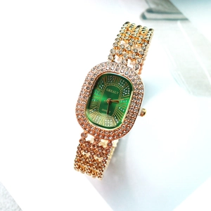Détail de montre luxe femme avec cadran vert et bracelet doré serti de strass