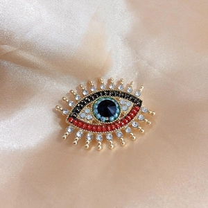 Vintage Evil Eye Brosche mit blauen Perlen und Kristallen auf Champagner-Satin