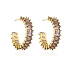 Close-up of C-shaped earrings in 18K gold plating with channel-set purple cubic zirconia