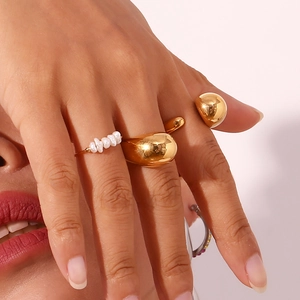 Detail shot of model wearing a gold wavy band and a delicate ring with small white pearls
