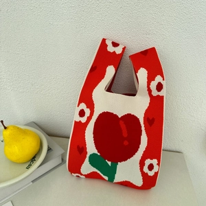 Close-up of knit tote bag with red heart pattern and soft fabric texture detail