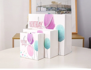 Three assorted sizes of birthday gift bags with watercolor balloons and rope handles