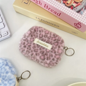 Dettaglio macro di pochette in peluche leopardate con cerniere ad anello in metallo