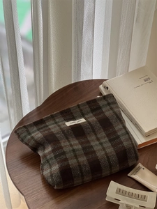 Detail of vintage brown plaid wool tweed makeup bag with zipper and woven label